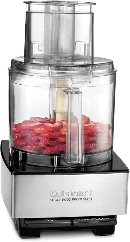 A close-up of the Cuisinart 14-cup food processor, filled with freshly sliced strawberries. The transparent container and stainless steel design emphasize its modern and functional aesthetic. The "On" and "Off-Pulse" buttons are clearly visible on the front panel.