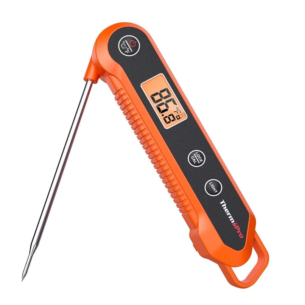 A close-up of the ThermoPro TP03H digital instant-read meat thermometer with an orange and black ergonomic design. The device features an easy-to-read backlit LCD screen, foldable stainless steel probe, and multiple control buttons for precise temperature measurement.